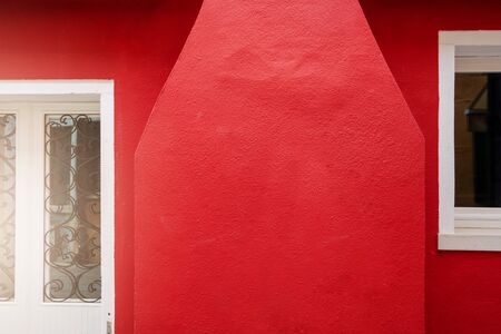 red outdoor wall cement texture with vintage door on abstract backgroundの写真素材