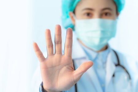 Coronavirus stop infection. young female doctor wearing mask with stethoscope against infectious diseases and flu. Healthcare conceptの写真素材