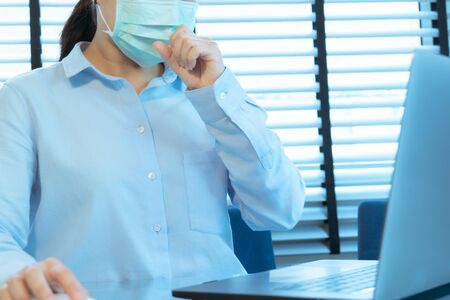 woman cough with face mask protection while working, Coronavirus, air pollution, allergic sick woman with medical maskの写真素材