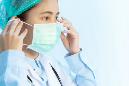 Coronavirus stop infection. young female doctor wearing mask with stethoscope against infectious diseases and flu. Healthcare conceptの写真素材