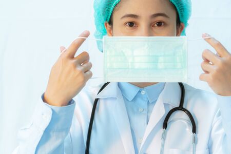 Coronavirus stop infection. young female doctor wearing mask with stethoscope against infectious diseases and flu. Healthcare conceptの写真素材