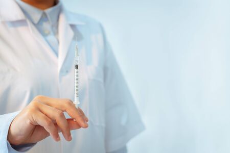Coronavirus stop infection. young female doctor with syringe and stethoscope against infectious diseases and flu. Healthcare, medical education, emergency medical service, surgery conceptの写真素材