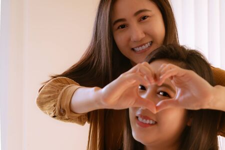 Happy Woman Day. two beautiful  Woman friends Holding Heart Shaped Hands. Healthy Eyes And Vision.の写真素材