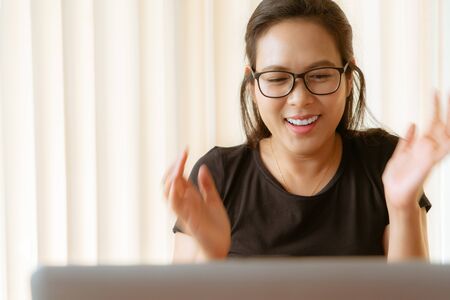 happy woman using laptop. Young Asian woman sitting at home and working on laptopの写真素材