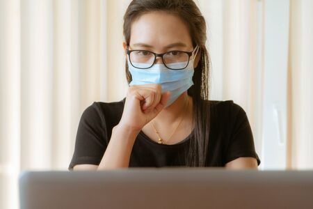 woman cough with face mask protection while working, Coronavirus, air pollution, allergy sick woman with medical maskの写真素材