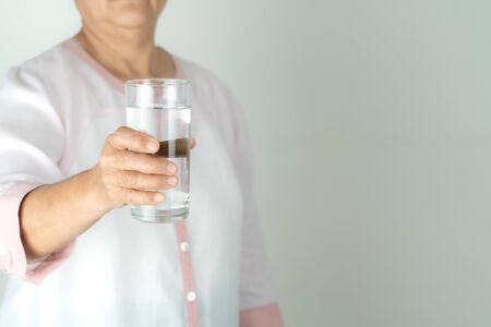 drinking water in the senior woman's hand, Concept of environment protection, healthy drink.の写真素材