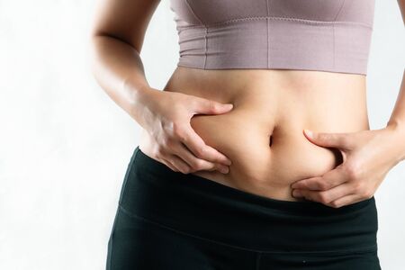 fat woman, fat belly, chubby, obese woman hand holding excessive belly fat, woman diet lifestyle conceptの写真素材