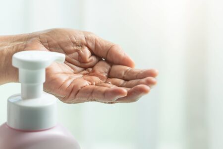 Covid-19 Coronavirus hand cleansing concept, senior hand apply alcohol gel or anti bacteria soap to make cleaning and clear virus, germ, bacteriaの写真素材