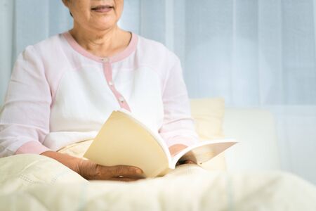 Covid-19 quarantine activity for senior woman read a book stay home to avoid riskの写真素材