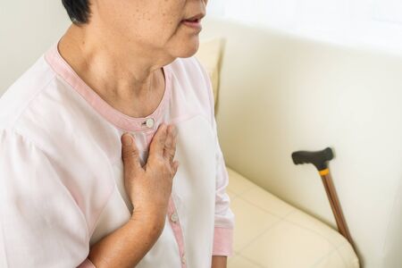 heart attack old woman holding chest in bed room, healthcare problem of senior conceptの写真素材