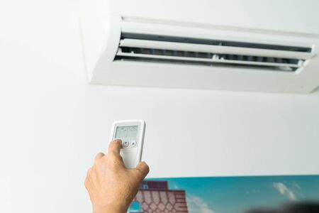 Remote control directed on air conditioner systrem, senior hand control air conditioner at homeの写真素材