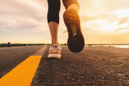 Athlete running on the road trail in sunset training for marathon and fitness. motion blur of woman exercising outdoorsの写真素材