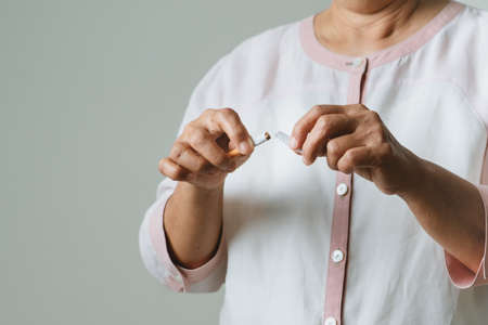 Quit smoking, no tobacco day, mother hands breaking the cigaretteの写真素材