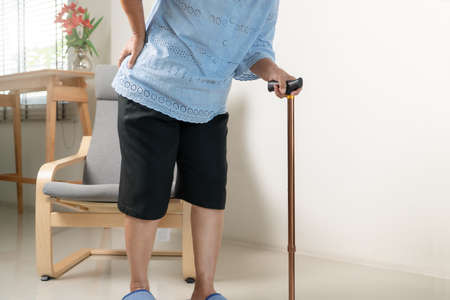 Old woman back pain at home, health problem conceptの写真素材