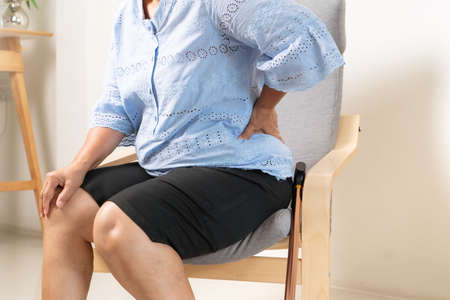 Old woman back pain at home, health problem conceptの写真素材