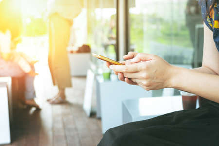 hand holding smartphone searching information on blurred backgroundの写真素材