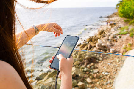 hand holding smartphone searching information on blurred backgroundの写真素材