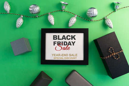 Black Friday Sale concept, gift box with photo frame on green backgroundの写真素材
