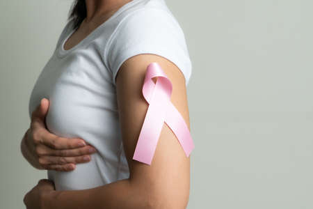 pink badge ribbon on woman arm to support breast cancer cause. breast cancer awareness conceptの写真素材