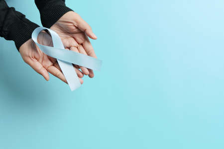 November light blue ribbon on woman hand with copy space, Prostate cancer awareness month, men's health conceptの写真素材