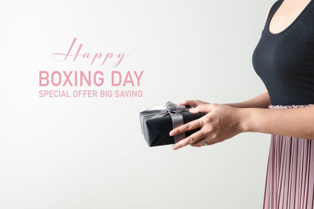 Boxing Day sale, young woman hold a gift box offer to receiver