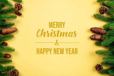 Christmas background, pine tree with xmas decoration on yellow backgroundの写真素材