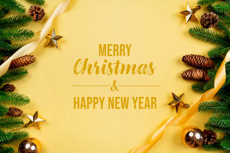 Christmas background, pine tree with xmas decoration on yellow backgroundの写真素材
