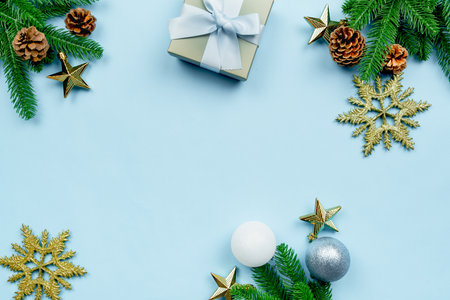Christmas present and pine tree with xmas decoration on blue backgroundの写真素材
