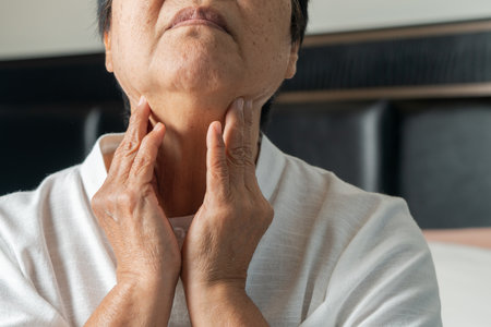 Senior adult women touching the neck feeling unwell coughing with sore throat pain.Healthcare and medicine conceptの写真素材