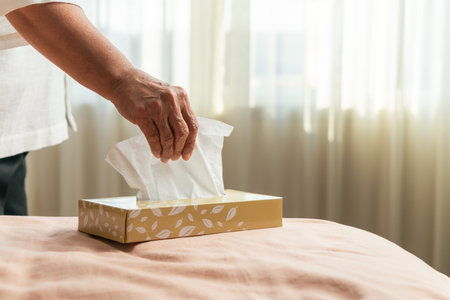 Senior women hand picking napkin/tissue paper from the tissue boxの写真素材