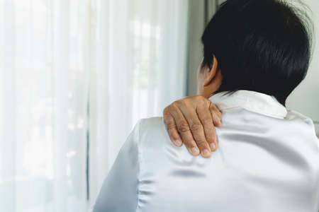 Old woman suffering from neck and shoulder injury, health problem conceptの写真素材