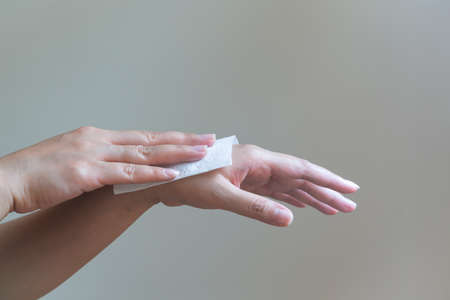 Woman cleaning her hands with white soft tissue paper. isolated on a white backgroundsの写真素材