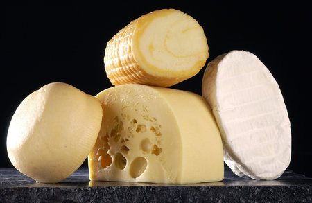 ripening and hard yellow cheeses on the background