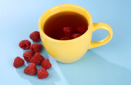 raspberry tea in a yellow cupの写真素材