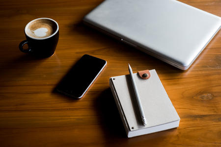 laptop, notebook and coffee on wooden backgroundの写真素材