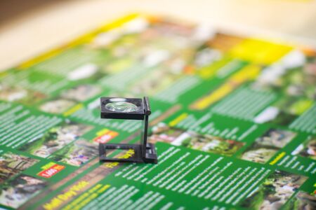 Black magnifying glass on colourfuk printed paper. Industrial printing process.のeditorial素材