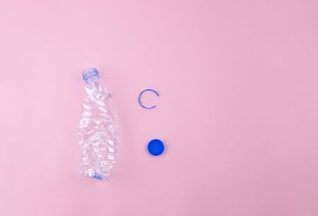 PET plastic bottle prepared for recycling, cap and ring taken off, plastic label removed, bottle crushed. Recycling concept with copy spaceの写真素材