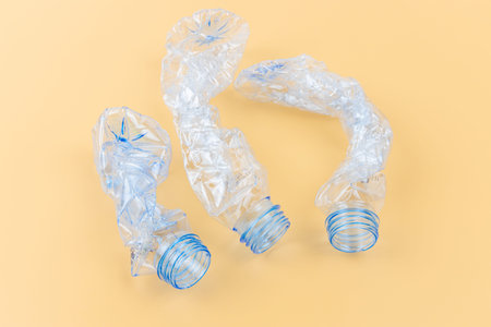 Set of three empty and clean transparent plastic bottle compressed close up shot on light colour...