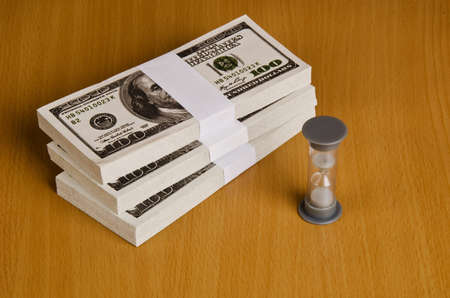 time sand and money are on a deskの写真素材