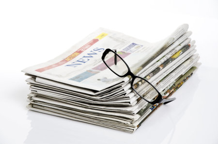 bird eye view of glasses on newspapers against white backgroundの写真素材