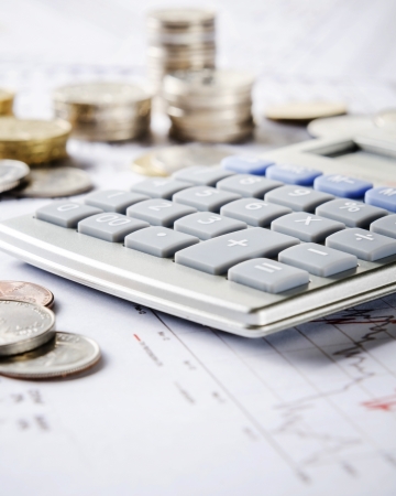 Closeup of calculator, coins and graphの写真素材