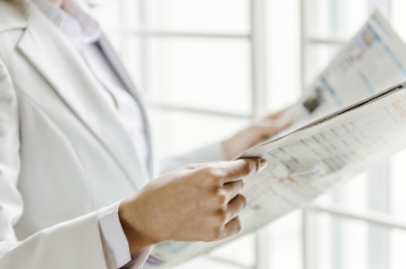 Closeup woman hand holding newspaperの写真素材