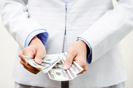 Businesswoman counting US currency in hands