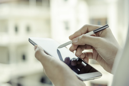Closeup of a woman hands using tablet with stylus penの写真素材