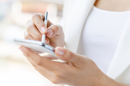 Closeup of a woman hands using tablet with stylus pen