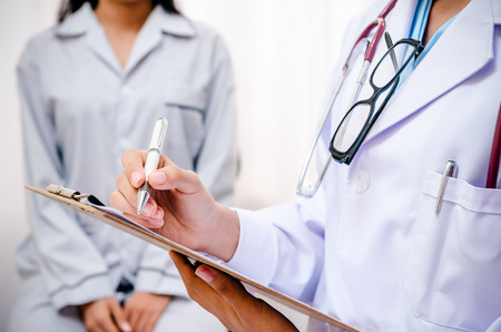 doctor writing patients record after examine healthの写真素材