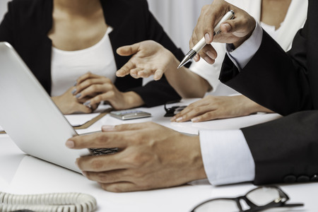 three business people discussing their work on a laptopの写真素材