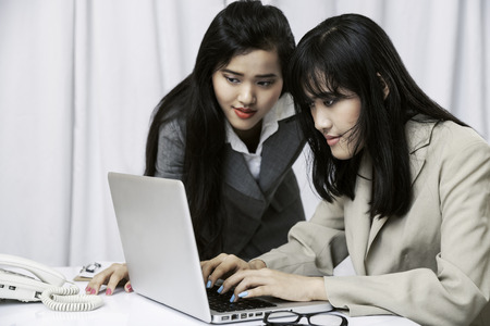 close up of businesswomen discussing work on computer in officeの写真素材