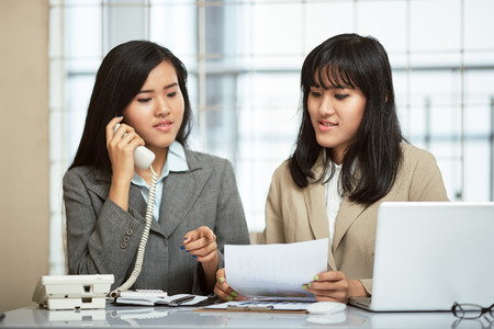 close up image of two businesswomen working and discussing in officeの写真素材