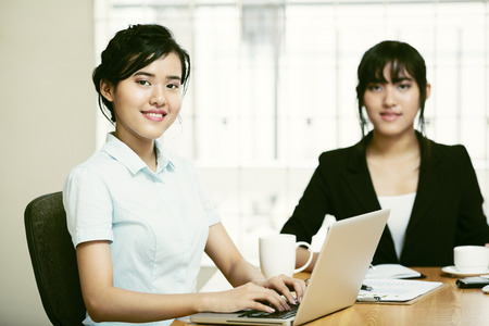 Beautiful young businesswomen working and typingの写真素材
